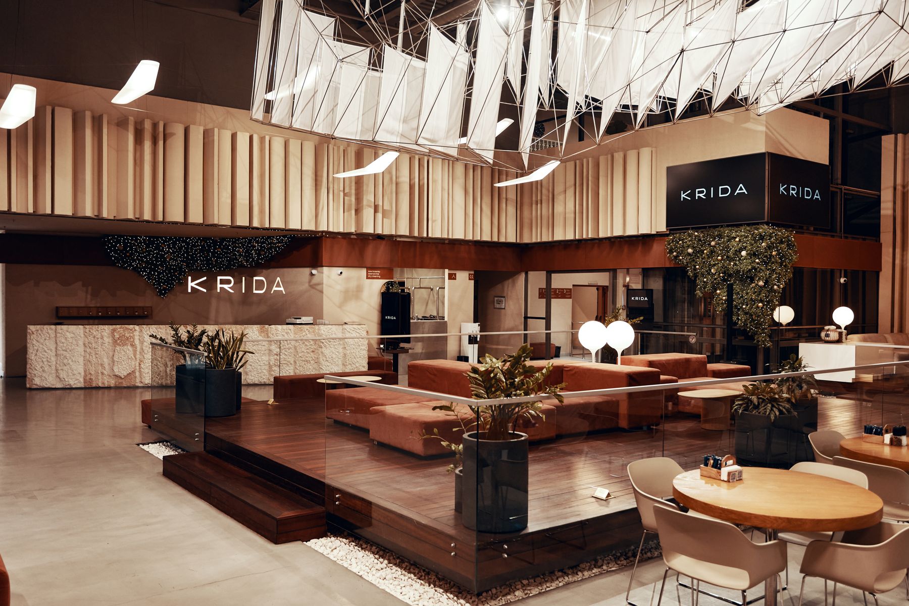 Лобби KRIDA: зона отдыха на подиуме, кафе и ресепшн с вывеской KRIDA